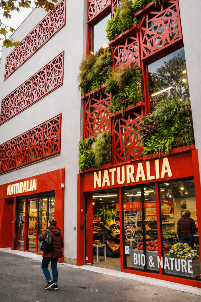 Façade végétalisée du magasin Naturalia, architecture rouge moderne et enseigne bio & nature.