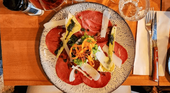 Entrée gastronomique servie au restaurant Le Soleil à Ivry-sur-Seine avec carpaccio et légumes frais