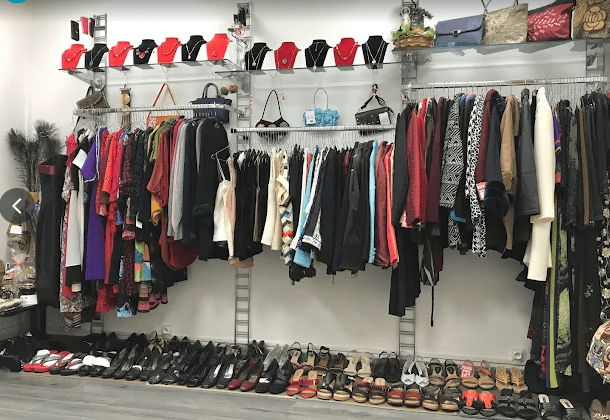 Intérieur de la boutique K.N Vêtements à Ivry-sur-Seine avec vêtements féminins, chaussures et accessoires de mode exposés en magasin.