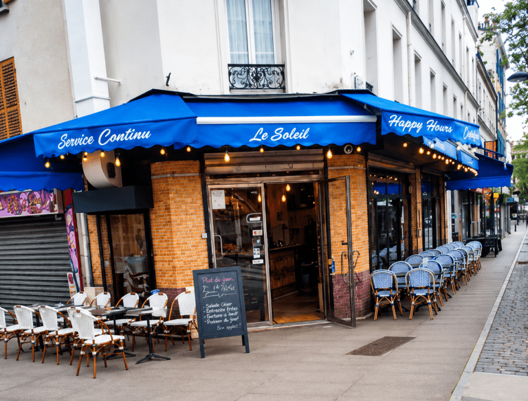 Terrasse du restaurant Le Soleil à Ivry-sur-Seine avec façade bleue et tables en extérieur