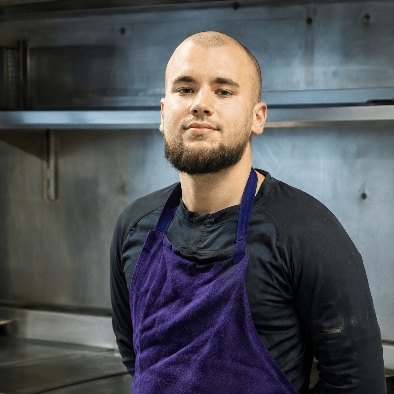 Jeune chef cuisinier posant dans les cuisines professionnelles d'un restaurant à Vitry-sur-Seine