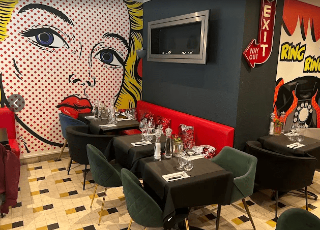 Salle de restaurant moderne et chaleureuse de La Villa à Blonville-sur-Mer avec décoration pop art, tables dressées et ambiance conviviale.