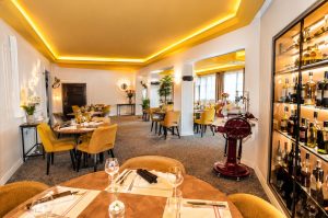 Salle de restaurant élégante de l'Auberge des Saints Pères avec une décoration contemporaine et une ambiance chaleureuse.