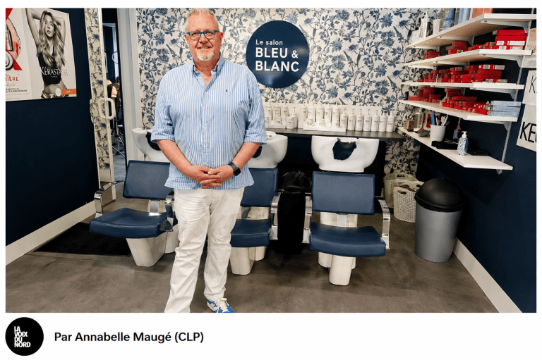 Le gérant du Salon Bleu & Blanc pose dans son salon de coiffure moderne, devant les bacs de lavage. Photo : Annabelle Maugé (CLP).