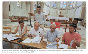 Signature de la convention entre des vignerons, des représentants de la commune et une association pour lancer une cuvée solidaire destinée à financer la restauration de l'église de Mauges-sur-Loire. Titre de l'image