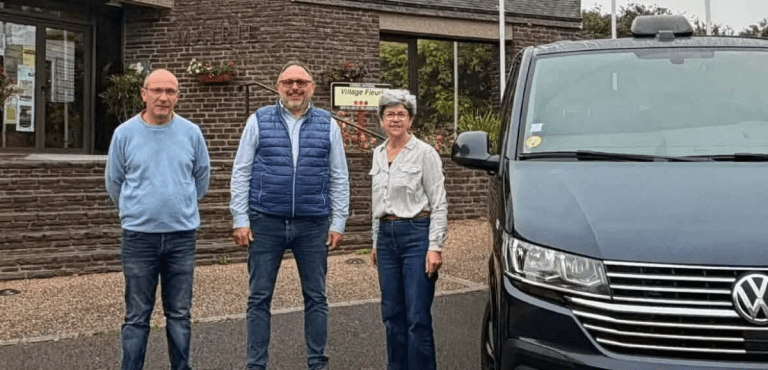 Élus et représentants devant un véhicule de transport solidaire devant le Village Fleuri à Deauville.