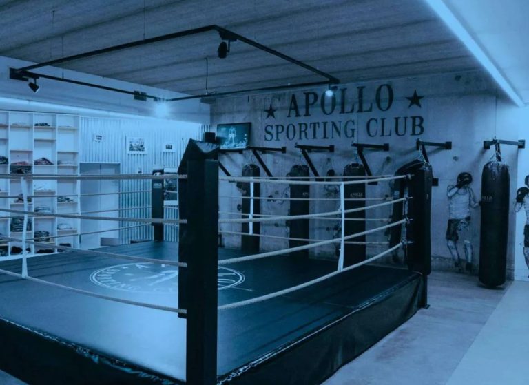 Salle de boxe de l’Apollo Sporting Club avec ring et sacs de frappe.