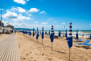 Plage de Blonville-sur-Mer (14910) avec parasols bleus et blancs face à la mer