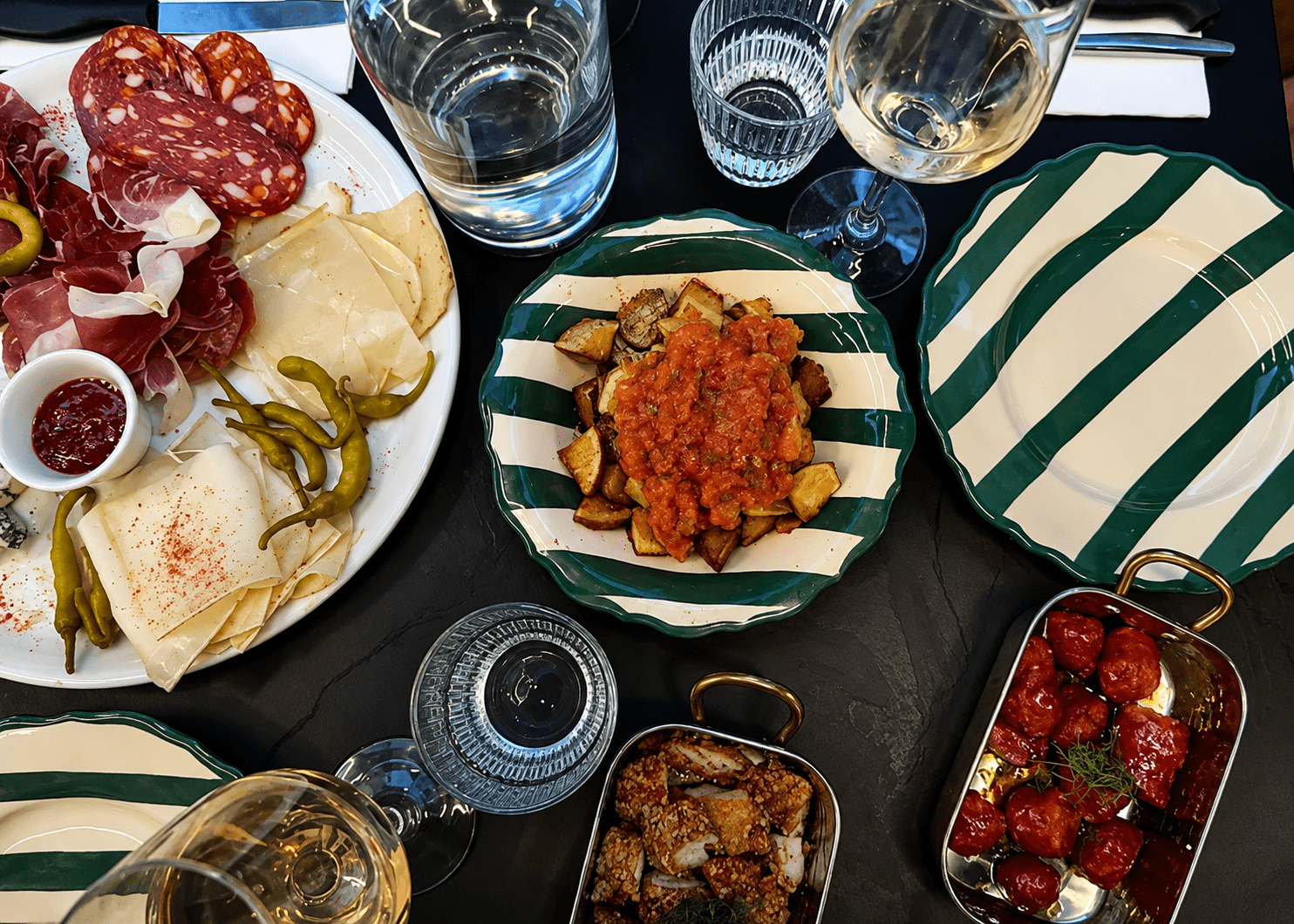 Table de restaurant avec charcuterie, fromages et spécialités italiennes