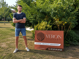 Jeune paysagiste de 25 ans devant le panneau de VERON Paysage en Maine-et-Loire (49)