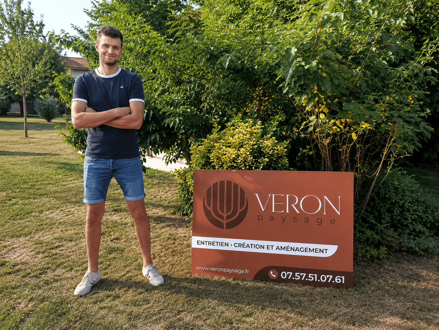 Jeune paysagiste de 25 ans devant le panneau de VERON Paysage en Maine-et-Loire (49)