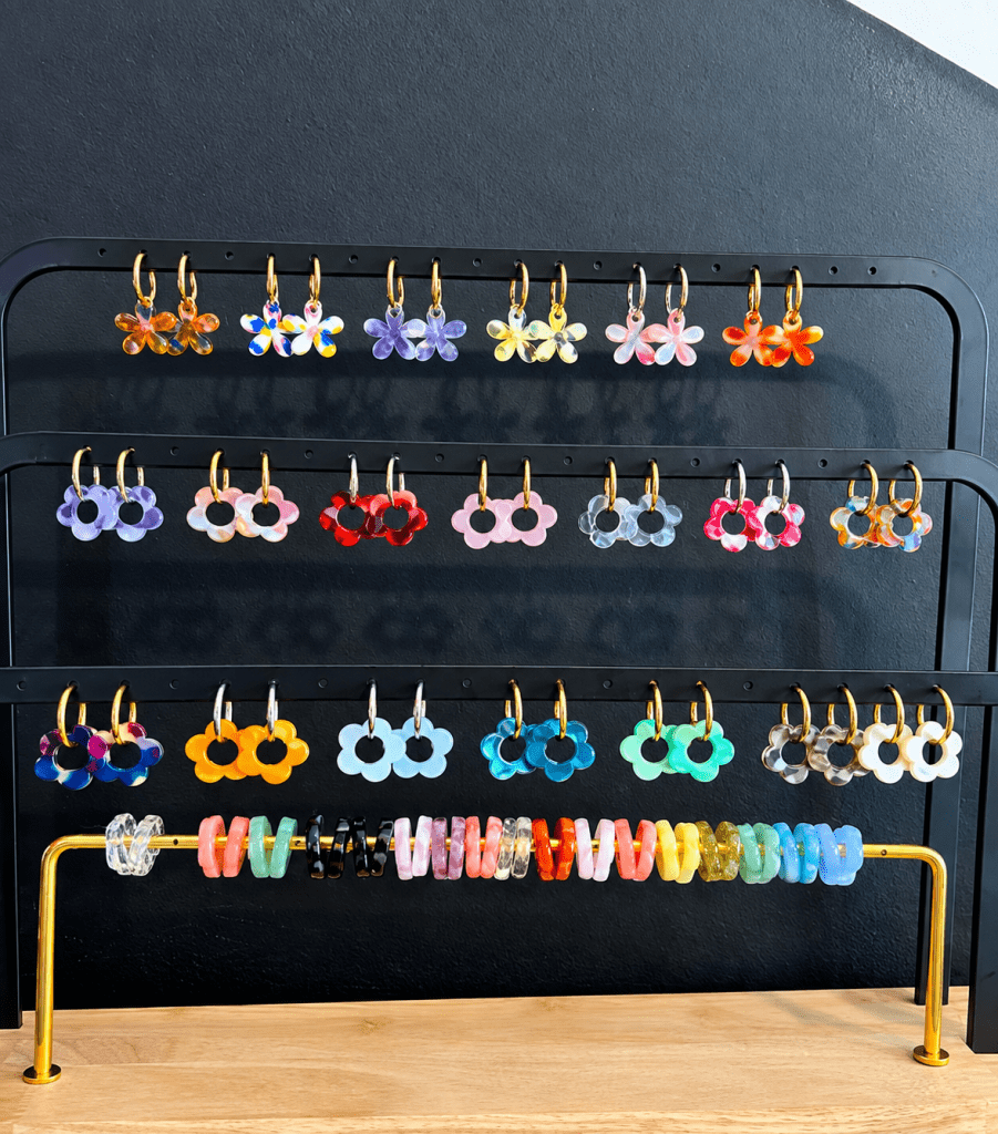 Boucles d’oreilles colorées en forme de fleurs présentées sur un présentoir