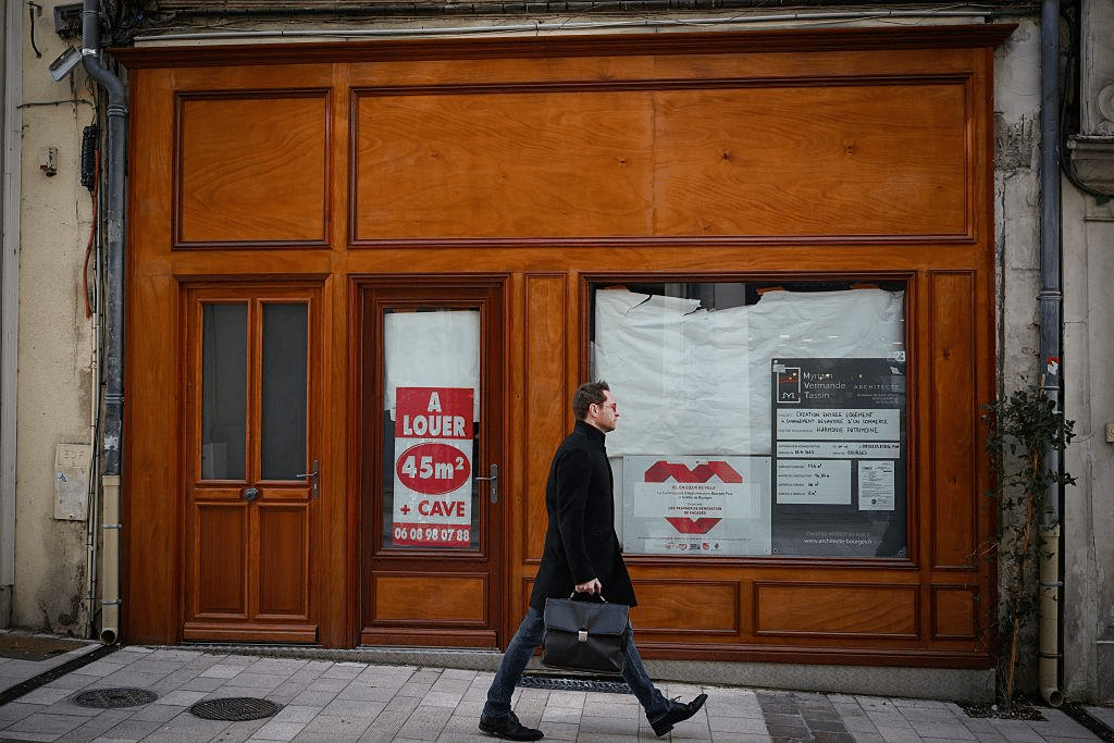 Local commercial vacant avec panneau « À louer » dans une rue de centre-ville.