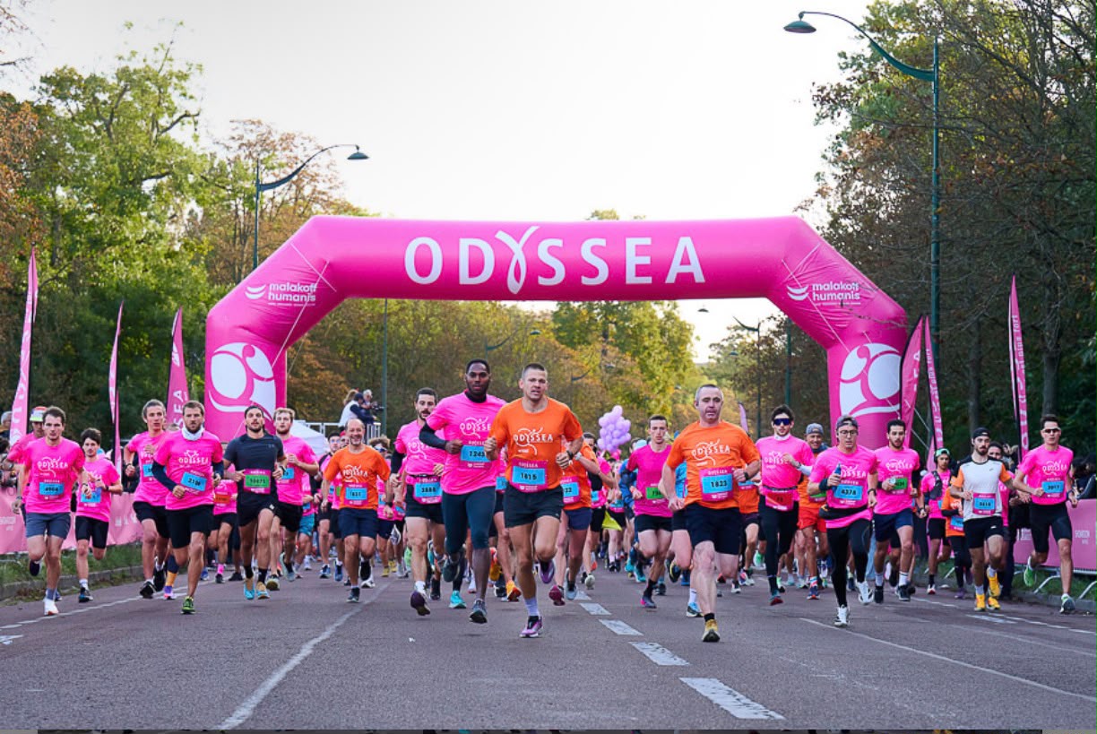 Coureurs participant à la course Odysséa Paris sous l’arche de départ
